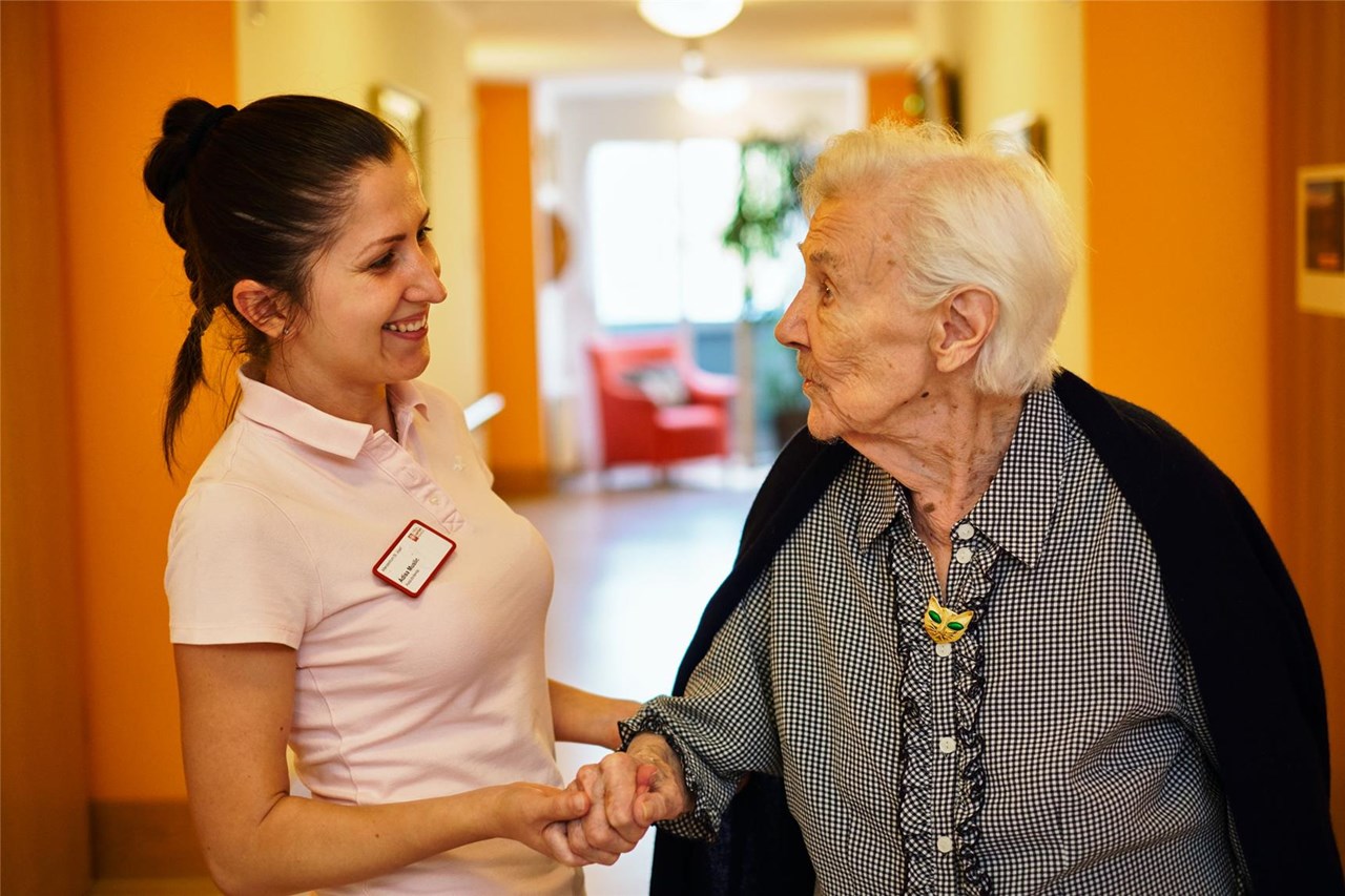 Pflegekraft begrüßt Seniorin im Pflegeheim St. Josef Frankfurt am Main